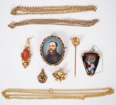 une photo d'une collection de bijoux comprenant un collier, une broche et la photo d'un homme