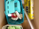 un carton contenant un aspirateur et un carton contenant une boîte de produits d'entretien