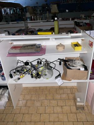 une étagère blanche sur laquelle sont posés tout un tas d'appareils électroniques