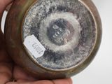 a person holding a brown vase with a tag on it