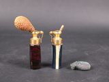 two bottles of perfume and a small fish on the table