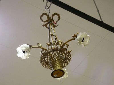 a chandelier hanging from the ceiling with flowers in it