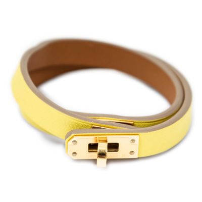 a close up of a yellow leather belt with a gold buckle