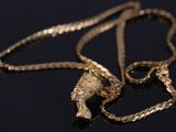 un collier en or orné d'une tête humaine