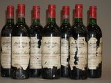 six bouteilles de vin rouge sont alignées sur une table
