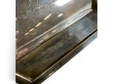 a silver tray with a handle on a white surface