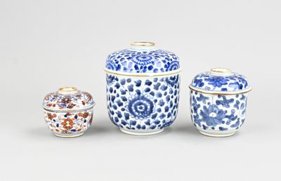 trois vases bleus et blancs avec leurs couvercles, posés sur une table
