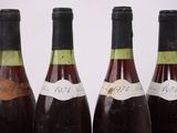 four bottles of wine are lined up on a table