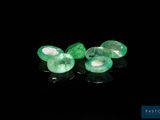 a pair of emeralds on a black surface