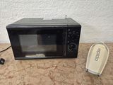 a microwave that is sitting on a table next to a phone