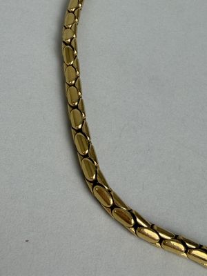 Collier en métal doré à maille articulée façon serpent.