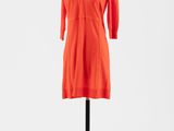 une robe orange posée sur un mannequin, sur fond blanc