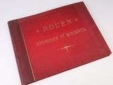 un vieux livre rouge posé sur une table blanche