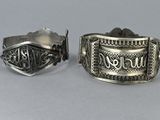 pair of silver cuff bracelets with the word never you engraved on them