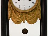 a clock hanging from the side of a black pole