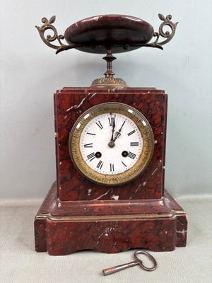 une horloge posée sur une table à côté d'une clé