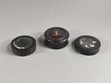trois petits récipients noirs et blancs posés sur une table