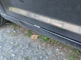 a black car that is parked on the side of the road