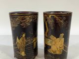 a pair of black and gold vases sitting on top of a table