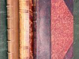 trois vieux livres posés les uns à côté des autres sur une table