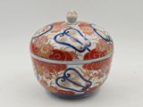 a red and blue bowl with a lid on a white surface