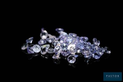 un gros plan sur un tas de diamants posés sur une surface noire