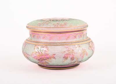 un vase rose et vert muni d'un couvercle, posé sur une surface blanche