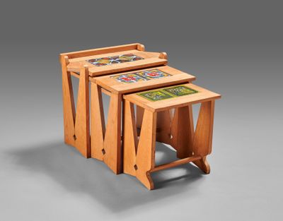three wooden nesting tables with tile designs on them on a gray background