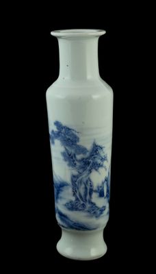 un vase bleu et blanc posé sur une surface noire