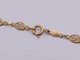 a gold bracelet with an intricate design on it