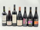 plusieurs bouteilles de vin sont alignées sur une surface blanche