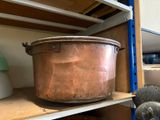 a large copper pot sitting on a shelf in a room