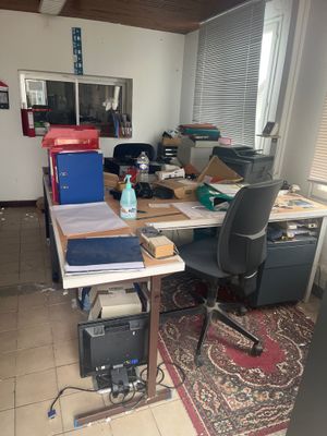 un bureau avec un ordinateur et une chaise dans une pièce