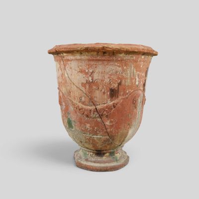 an old vase with a face on it on a table