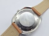 the back of a watch with a leather strap on a white surface