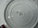 a person holding a white plate with a smiley face on it