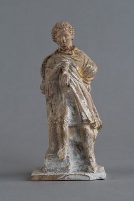 statue d'un homme portant un chapeau et une robe, sur fond gris