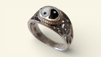 silver ring with black and white stone eyes on it