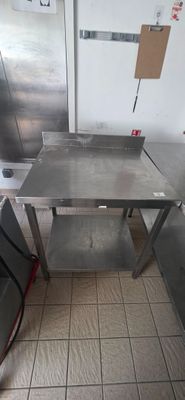 a stainless steel table in the middle of a kitchen