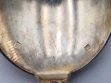 a silver spoon with a handle that has a picture of a woman on it
