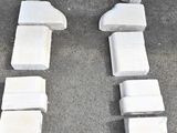 a white bench made out of concrete blocks on the ground