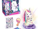 une licorne en peluche posée sur une table, à côté d'une boîte d'autocollants
