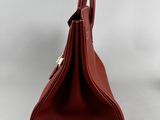 a close up of a brown purse on a white surface