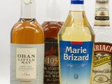bottles of various types of alcohol are lined up on a white surface