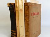 trois livres sont empilés sur une surface blanche