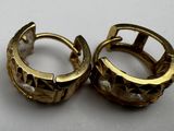 pair of gold tone hoop earrings on a white surface