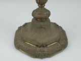an antique brass candle holder on a white background