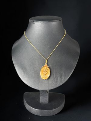un collier en or avec un pendentif jaune sur un mannequin noir