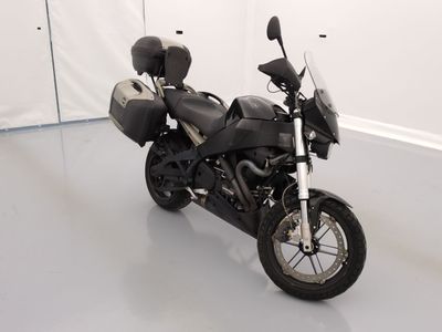 une moto noire garée dans une pièce aux murs blancs
