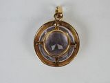 a close up of a pendant on a white surface